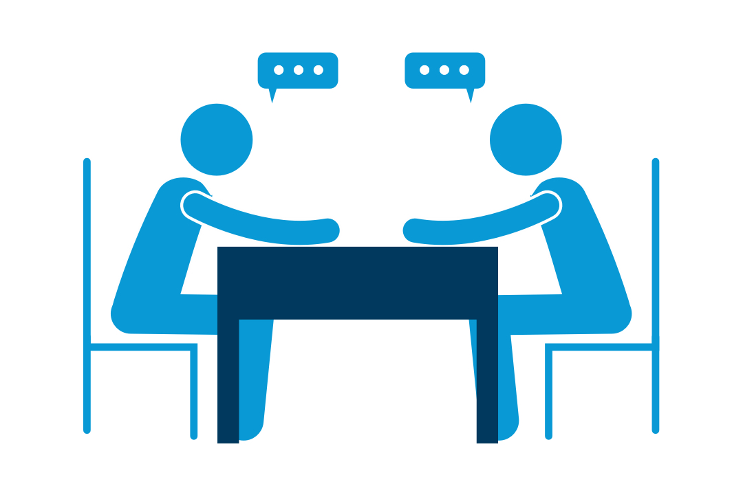Two people talking at desk